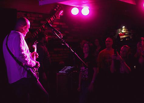 Pieter performing live on electric guitar in a venue